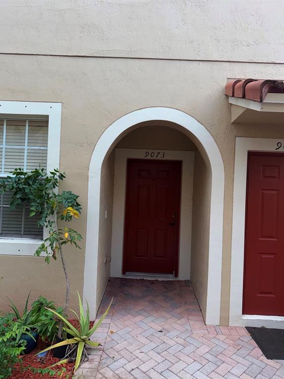 9073 Plymouth Place Tamarac, FL 33321 - Photo 4 of 16 a front view of a house with potted plants