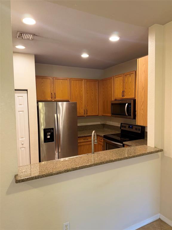 9073 Plymouth Place Tamarac, FL 33321 - Photo 10 of 16 a kitchen with granite countertop a refrigerator and a sink
