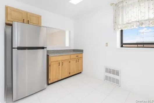 a view of kitchen with refrigerator and cabinet