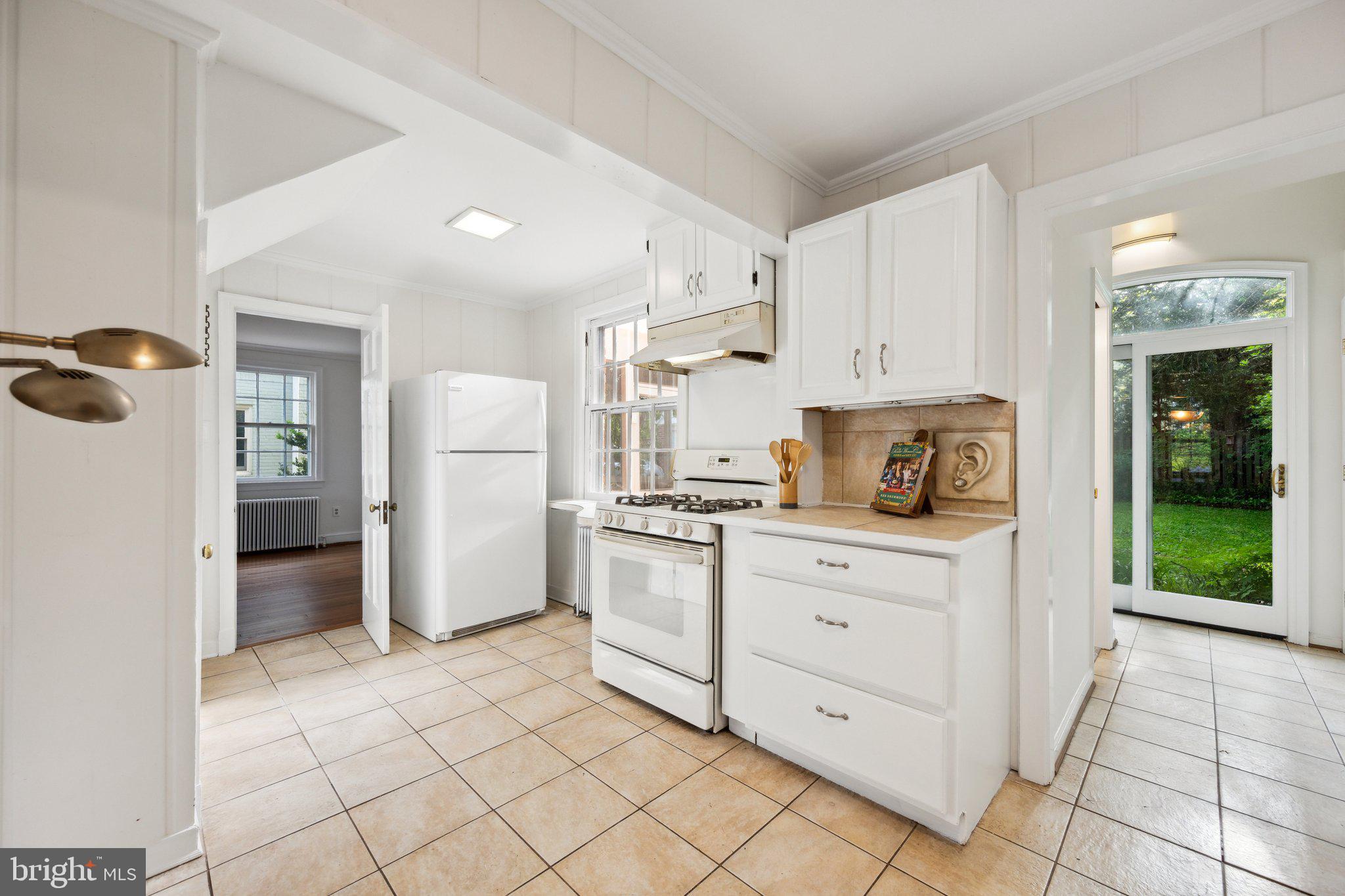7820 Custer Road Bethesda, MD 20814 - Photo 6 of 29 a kitchen with white cabinets and refrigerator