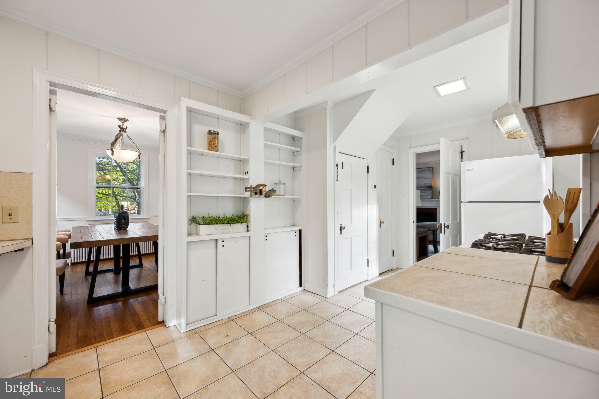 7820 Custer Road Bethesda, MD 20814 - Photo 7 of 29 a kitchen with a refrigerator and table