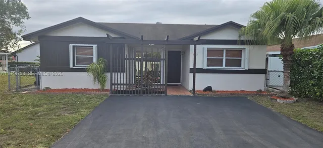 a view of a house with backyard and a garden