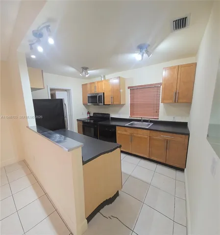 a kitchen with kitchen island granite countertop a stove and a sink
