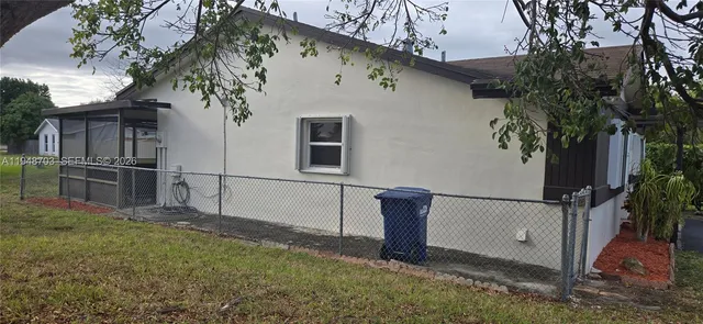 a view of backyard with potted plants and large tree
