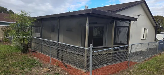 a view of a wooden house with a large window and wooden fence