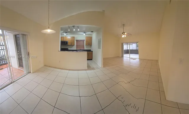 a view of a kitchen with a sink and an empty room