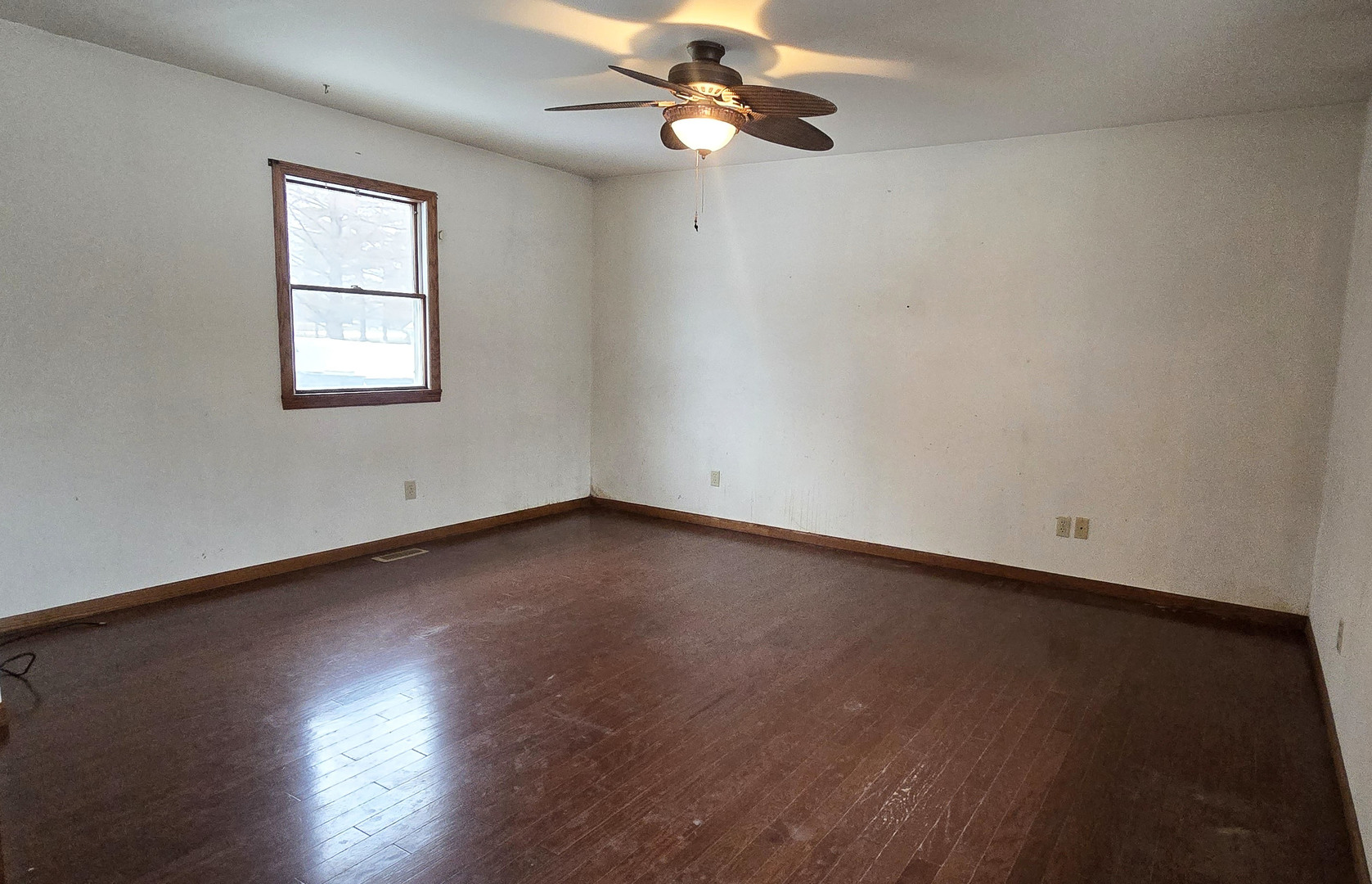 1115 South Clapper Court Mahomet, IL 61853 - Photo 6 of 16 an empty room with wooden floor chandelier fan and windows
