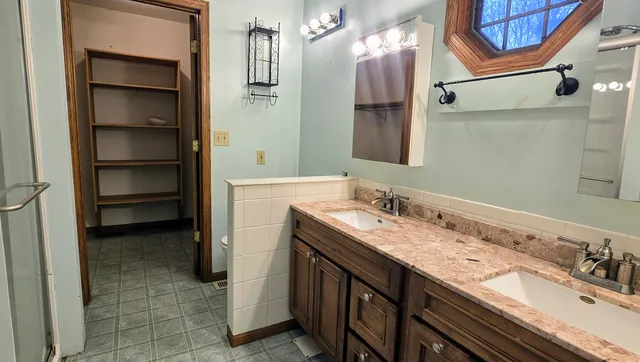 a bathroom with a granite countertop sink and a mirror