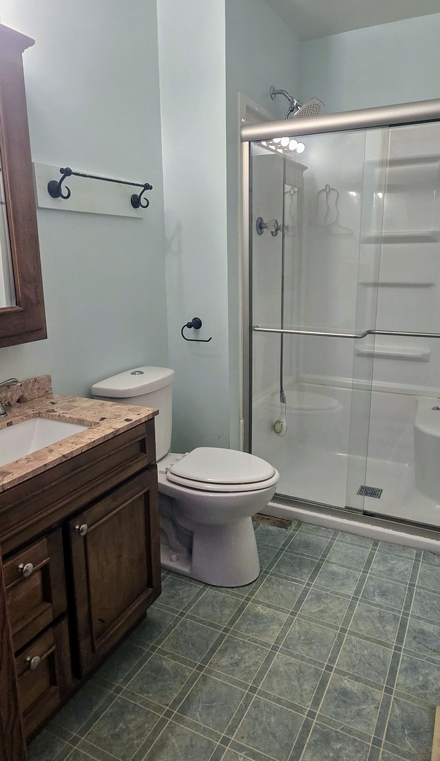 1115 South Clapper Court Mahomet, IL 61853 - Photo 10 of 16 a bathroom with a granite countertop toilet a sink and shower