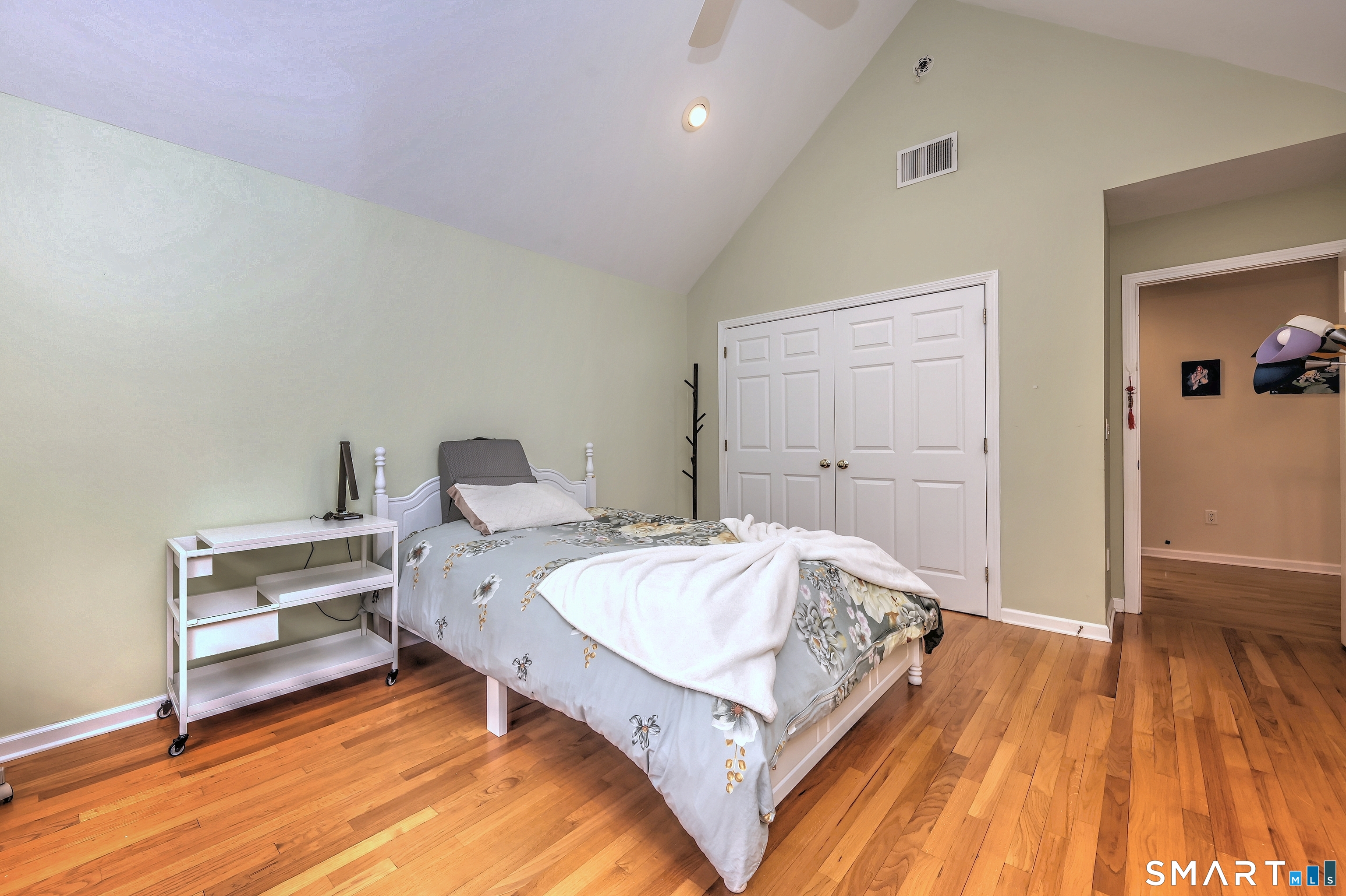 125 Peck Hill Road Woodbridge, CT 06525 - Photo 25 of 40 a spacious bedroom with a bed and a wooden floor