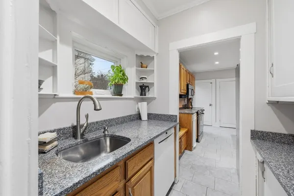 a kitchen with granite countertop a sink and a stove
