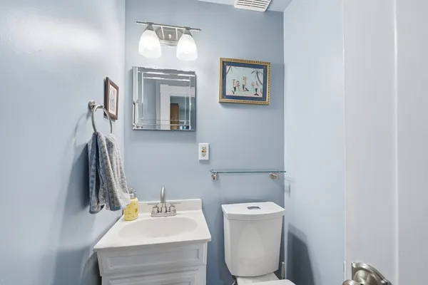 a bathroom with a toilet a sink and mirror
