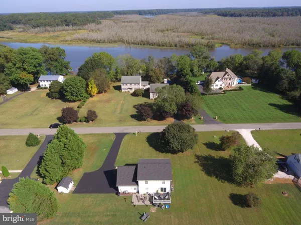 an aerial view of a house with a garden and lake view