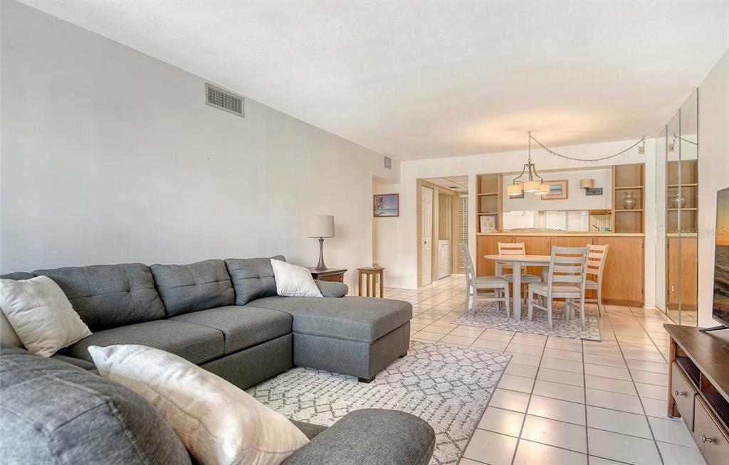 6157 Midnight Pass Road, Unit E63 Sarasota, FL 34242 - Photo 15 of 61 a living room with furniture and a dining table with kitchen view