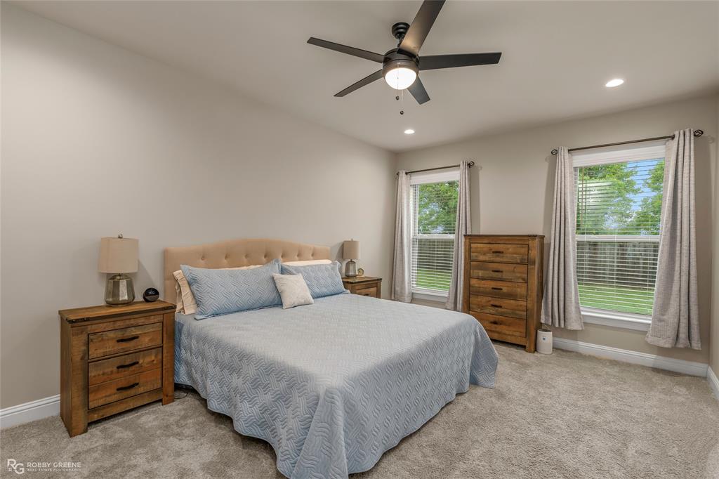 122 Brimestone Loop Benton, LA 71006 - Photo 15 of 33 a spacious bedroom with a bed a dresser and a chandelier