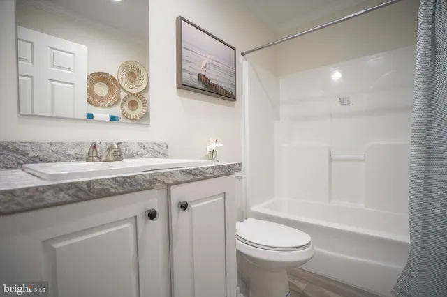 a bathroom with a granite countertop sink mirror vanity and toilet