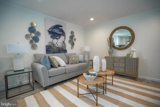 a living room with furniture a mirror and a wooden floor