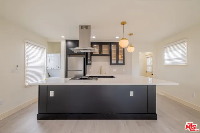 a large kitchen with granite countertop a sink cabinets and stainless steel appliances
