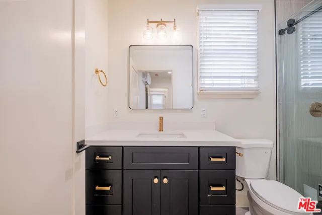 a bathroom with a sink vanity mirror and toilet