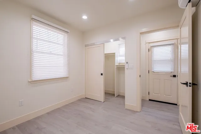 a view of an empty room with closet and a window