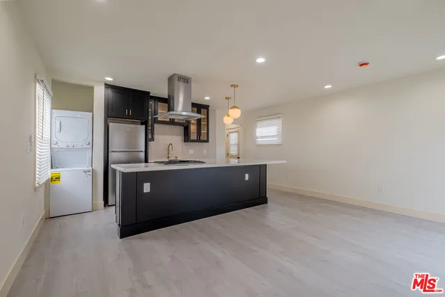 a large kitchen with a sink and dishwasher a refrigerator with wooden floor