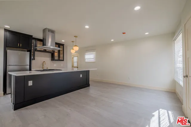 a large kitchen with kitchen island a sink stainless steel appliances and a window
