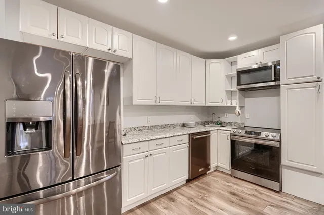 a kitchen with stainless steel appliances granite countertop a refrigerator sink and cabinets