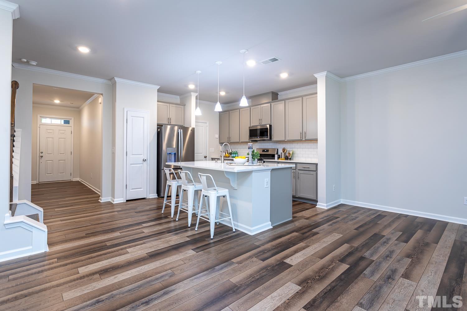 6531 Tremolo Trail Raleigh, NC 27616 - Photo 2 of 13 a kitchen with kitchen island granite countertop a sink cabinets and stainless steel appliances