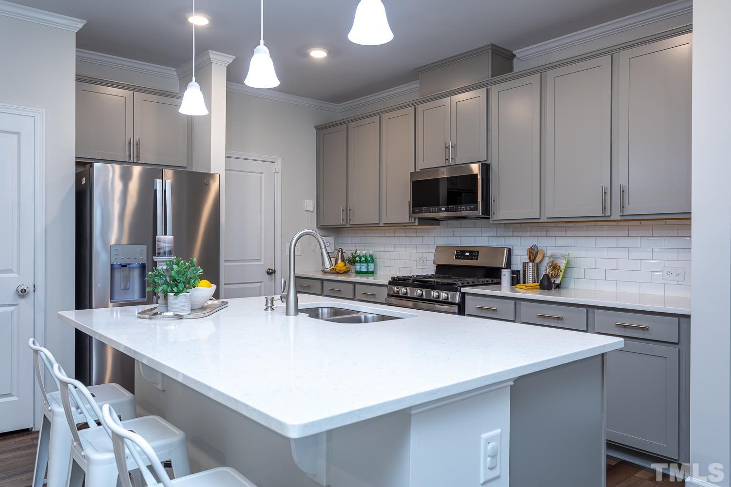 6531 Tremolo Trail Raleigh, NC 27616 - Photo 3 of 13 a kitchen with stainless steel appliances a stove a sink a refrigerator and cabinets