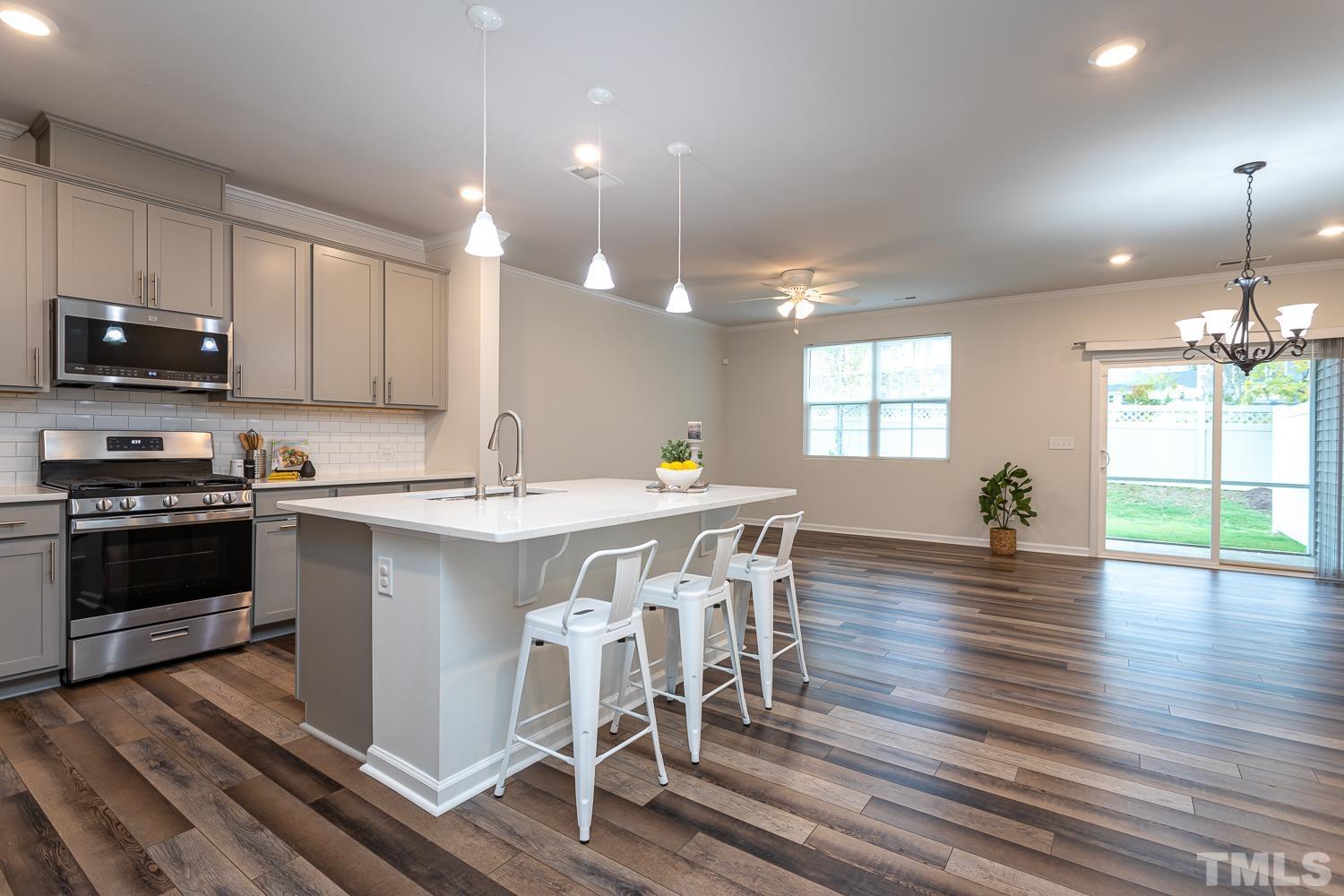 6531 Tremolo Trail Raleigh, NC 27616 - Photo 4 of 13 a kitchen with a table chairs a sink dishwasher window and cabinets
