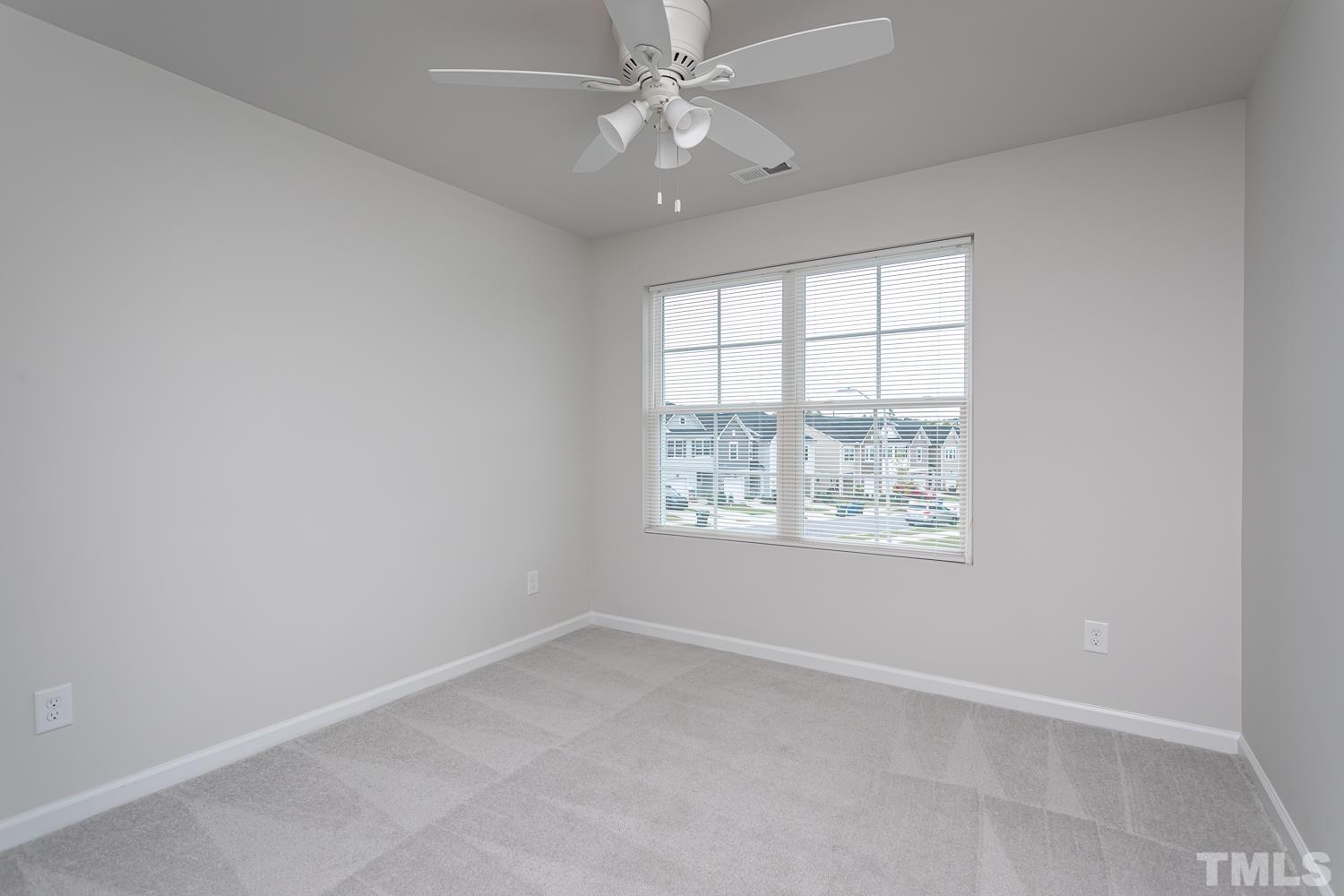 6531 Tremolo Trail Raleigh, NC 27616 - Photo 9 of 13 an empty room with windows and a ceiling fan