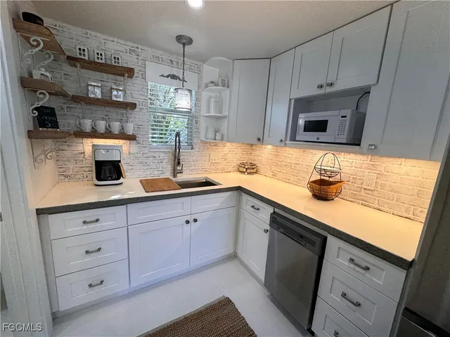a kitchen with stainless steel appliances granite countertop a sink a stove and cabinets