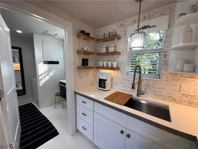 a kitchen with granite countertop a sink stainless steel appliances and cabinets