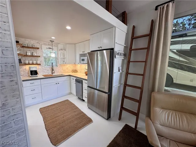 a kitchen with stainless steel appliances a refrigerator sink and cabinets