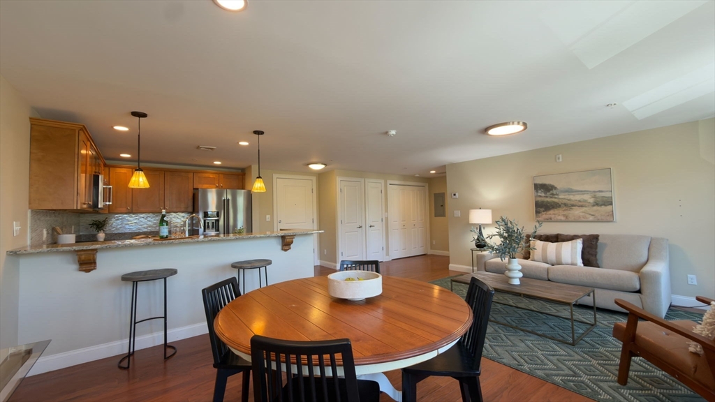70 Great Road, Unit G Bedford, MA 01730 - Photo 9 of 15 a view of a dining room with furniture and wooden floor