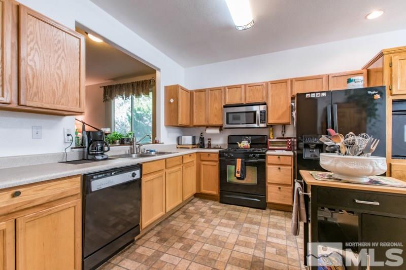 2771 Harding Way Reno, NV 89503 - Photo 7 of 24 a kitchen with stainless steel appliances granite countertop a stove top oven a sink dishwasher and a refrigerator with wooden cabinets