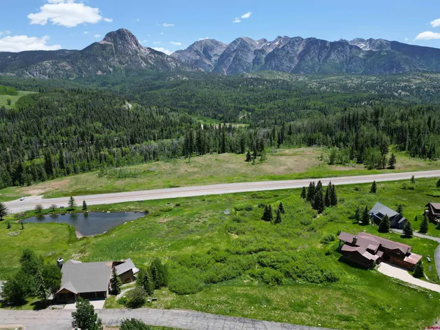 a view of a house with a yard and a forest