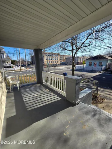 a view of a porch with furniture and a yard