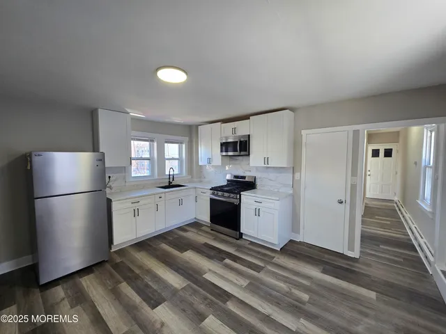a kitchen with a refrigerator a stove top oven a sink and dishwasher
