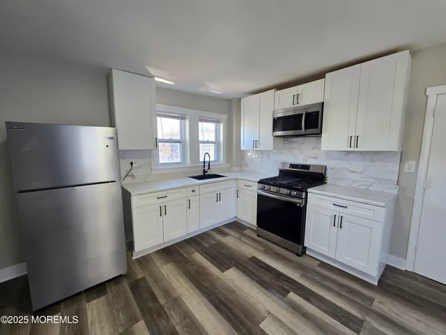 a kitchen with white cabinets and white appliances
