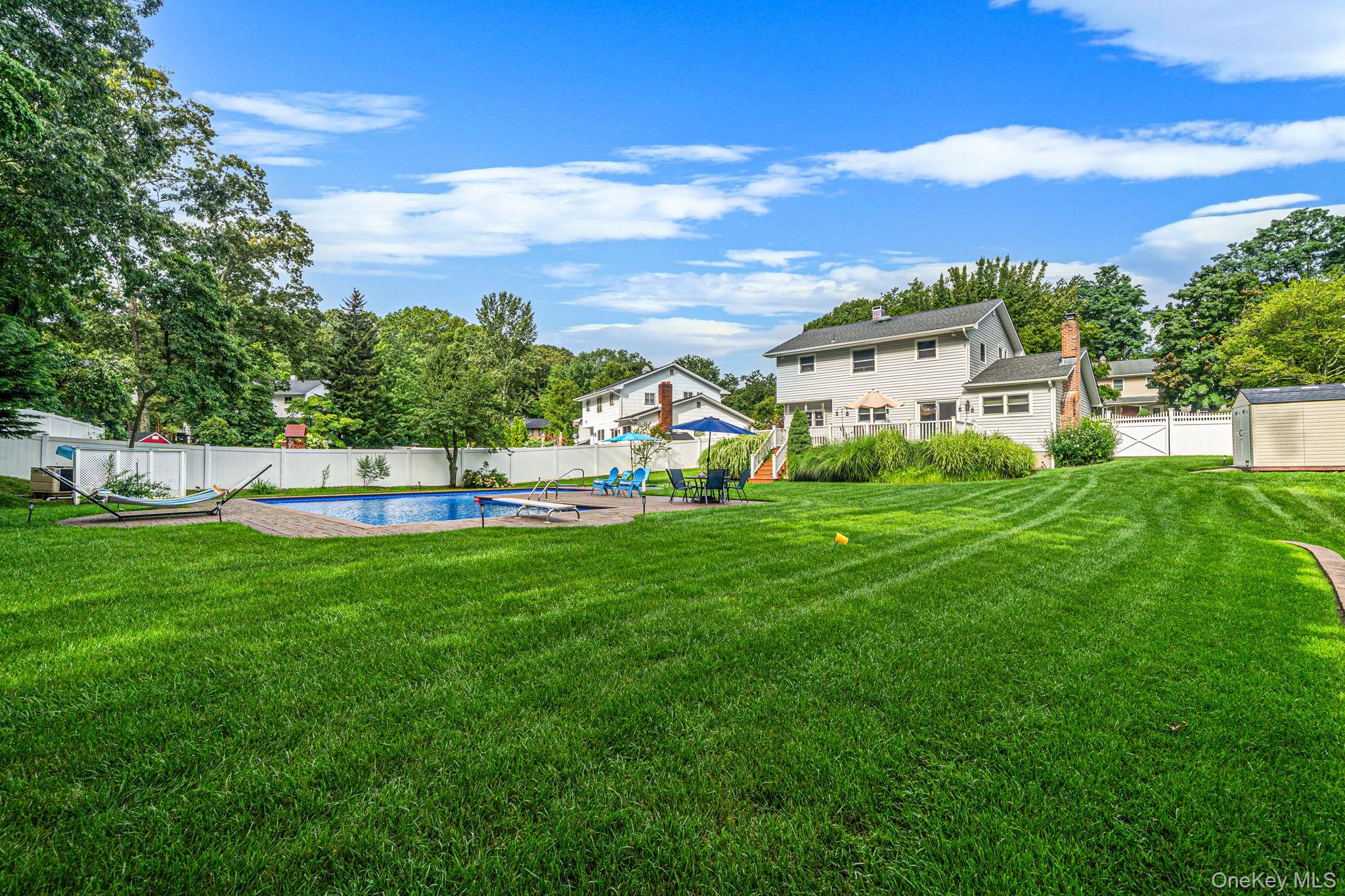 5 Rockhill Road Rocky Point, NY 11778 - Photo 44 of 48 Expansive backyard featuring a large in-ground swimming pool, a substantial lawn area, perimeter fencing, and a detached storage shed