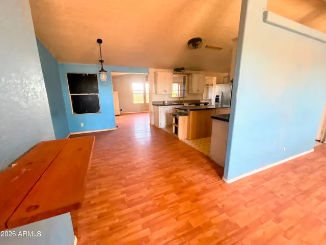 a living room with stainless steel appliances kitchen island granite countertop a sink and cabinets