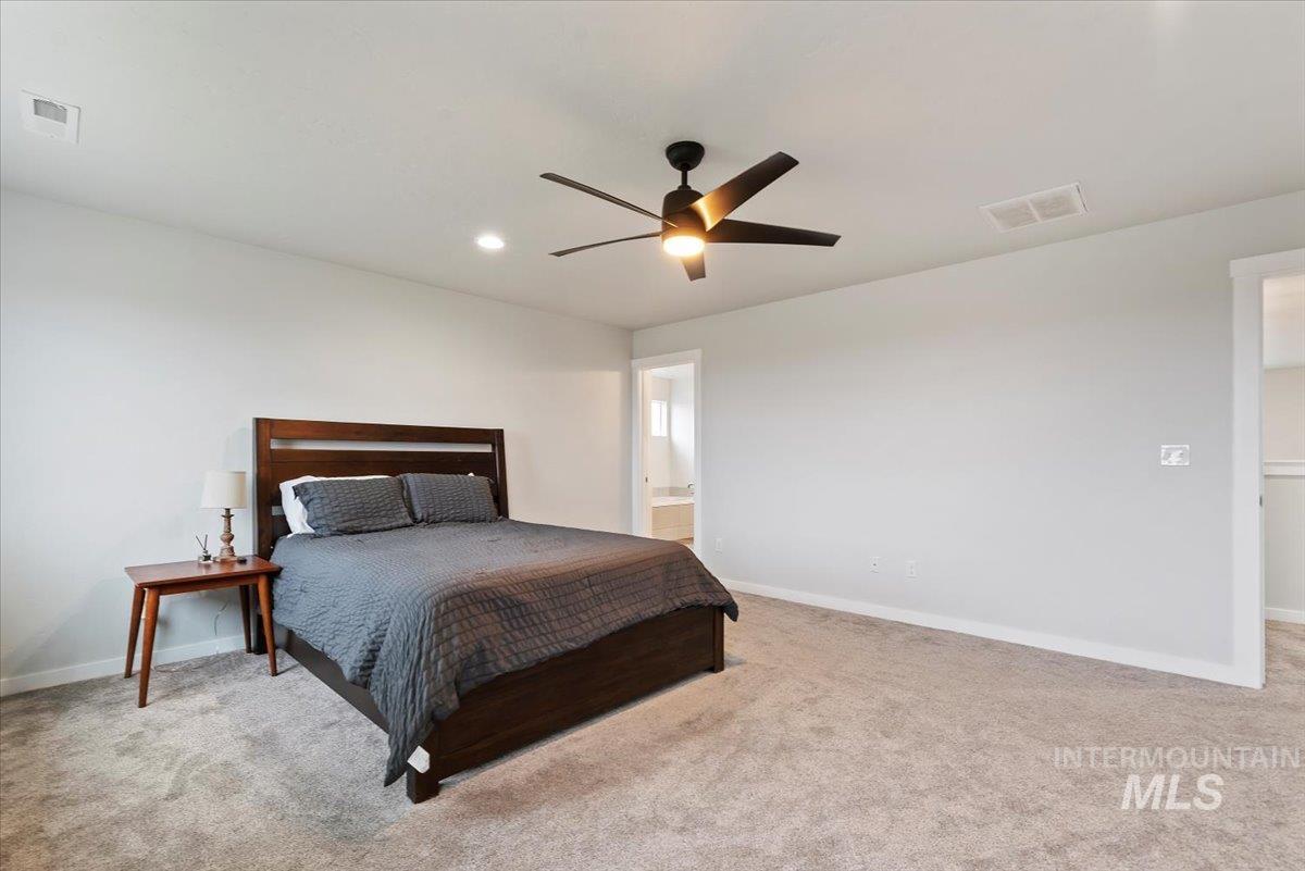 4086 North Kithnos Avenue Meridian, ID 83646 - Photo 13 of 29 Bedroom featuring light carpet, a ceiling fan, ensuite bathroom, and recessed lighting