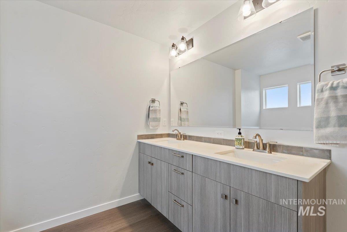 4086 North Kithnos Avenue Meridian, ID 83646 - Photo 14 of 29 Bathroom with double vanity and dark wood-type flooring