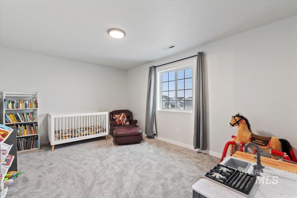 4086 North Kithnos Avenue Meridian, ID 83646 - Photo 19 of 29 Bedroom with a crib and light colored carpet and walk-in closet.