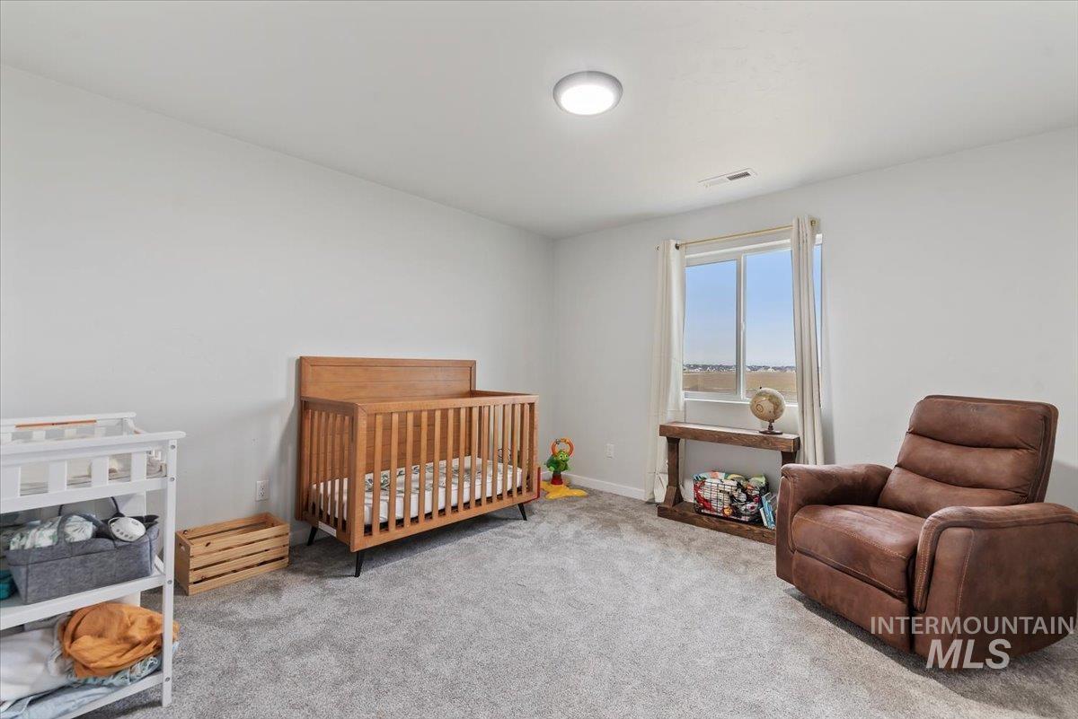 4086 North Kithnos Avenue Meridian, ID 83646 - Photo 20 of 29 Carpeted bedroom featuring a crib and baseboards and walk-in closet