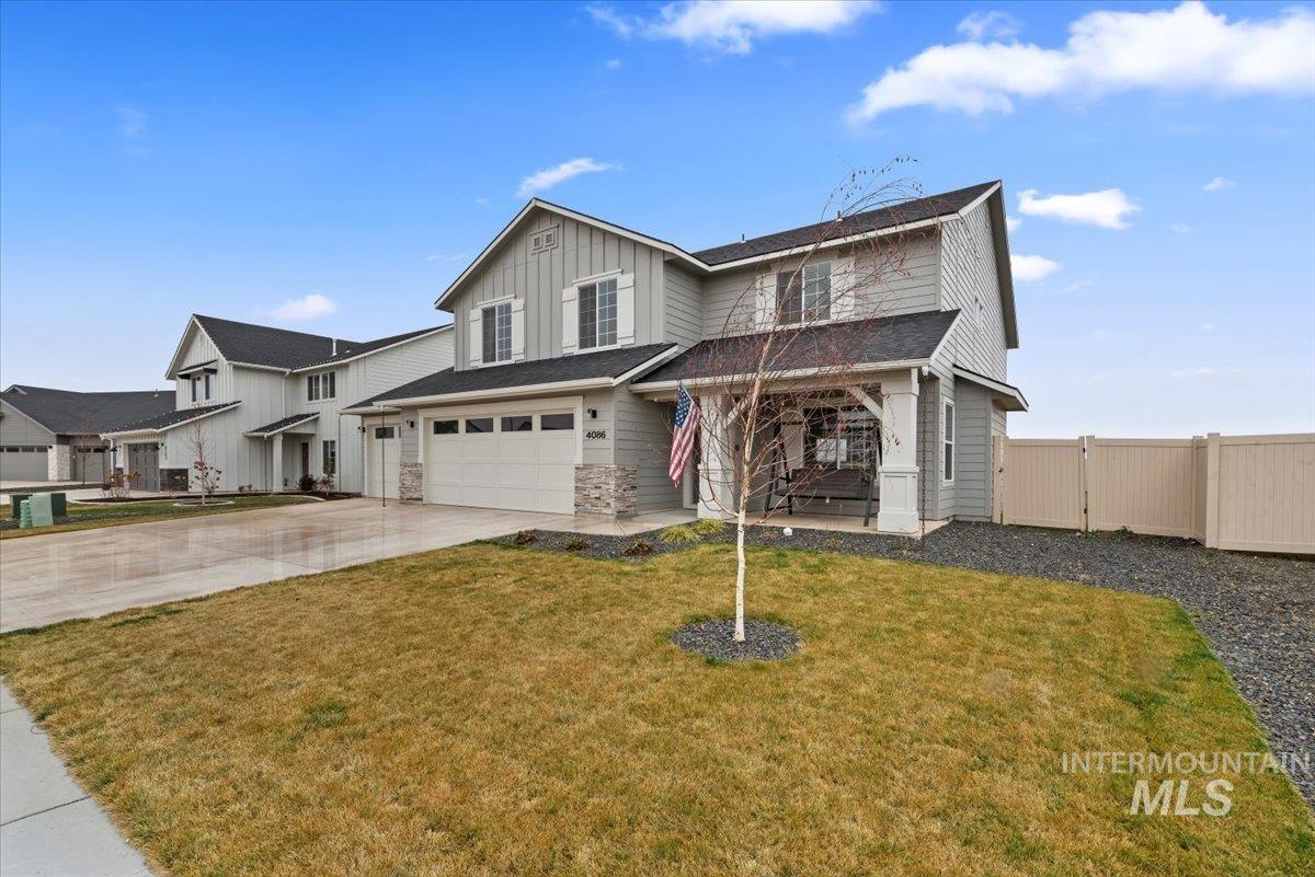 4086 North Kithnos Avenue Meridian, ID 83646 - Photo 2 of 29 View of front facade featuring board and batten siding, driveway, a gate, an attached garage, and stone siding