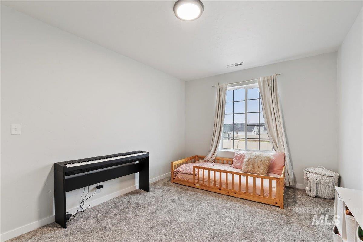 4086 North Kithnos Avenue Meridian, ID 83646 - Photo 22 of 29 Bedroom with baseboards and carpet flooring and walk-in closet.