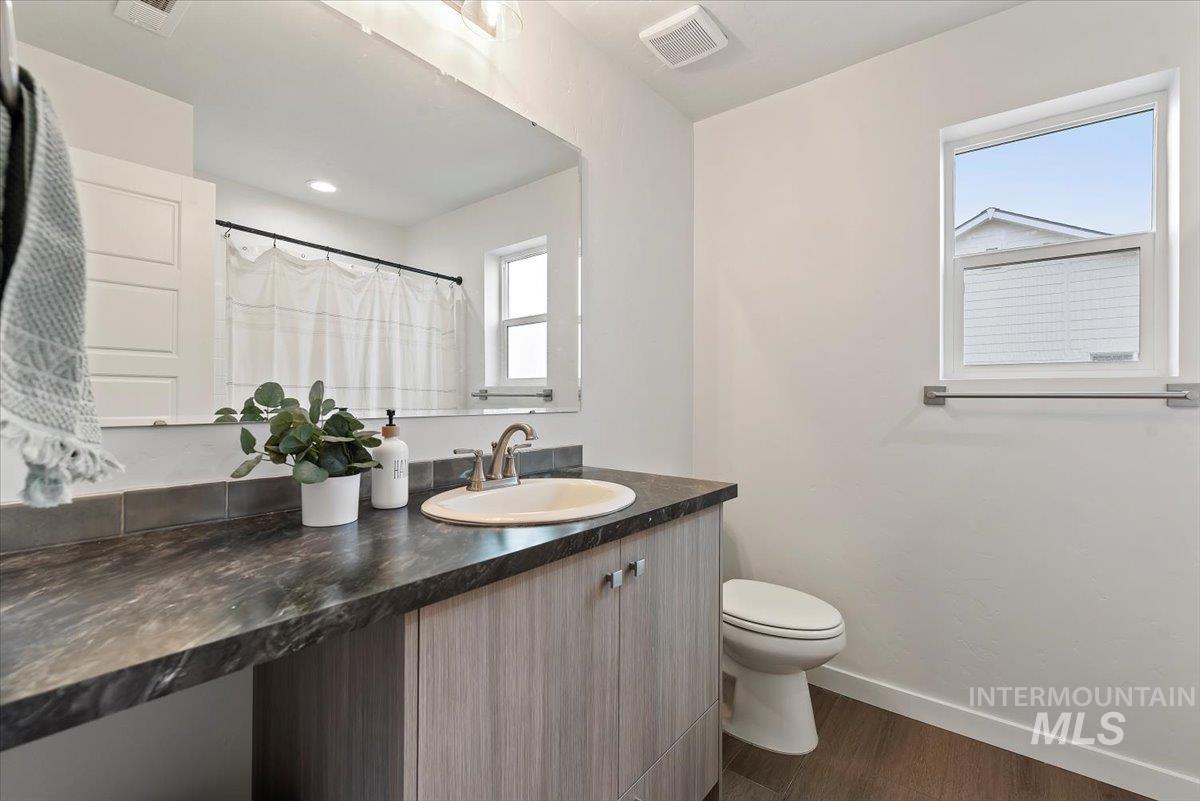 4086 North Kithnos Avenue Meridian, ID 83646 - Photo 23 of 29 Bathroom featuring curtained shower, vanity, and dark wood-style floors