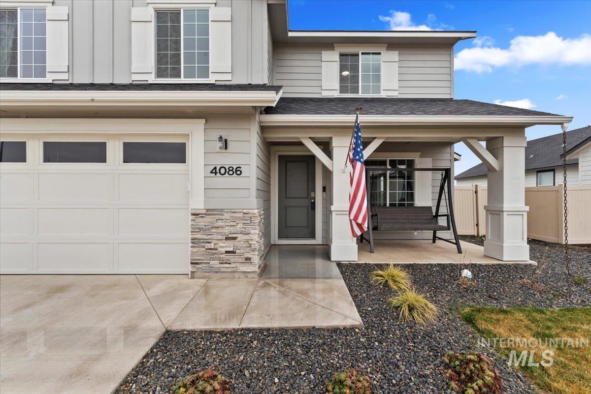 4086 North Kithnos Avenue Meridian, ID 83646 - Photo 3 of 29 Property entrance with a shingled roof, stone siding, and a porch